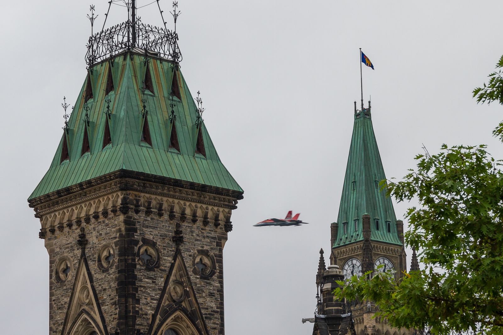 A CF-18 darts between the Parliament Buildings.
